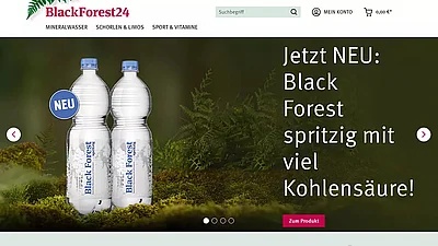 Screenshot der Hero-Section des Online-Shops mit der Abbildung von zwei PET-Flaschen vor einem Waldhintergrund.