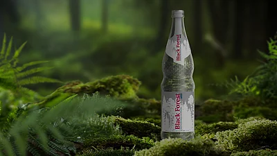 Eine Flasche Blackforest still steht auf einem bemoosten Stein in einem dunklen Wald.