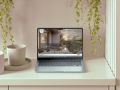 Laptop auf hellem Schreibtisch mit Immobilien-Website auf dem Bildschirm, umgeben von Zimmerpflanzen