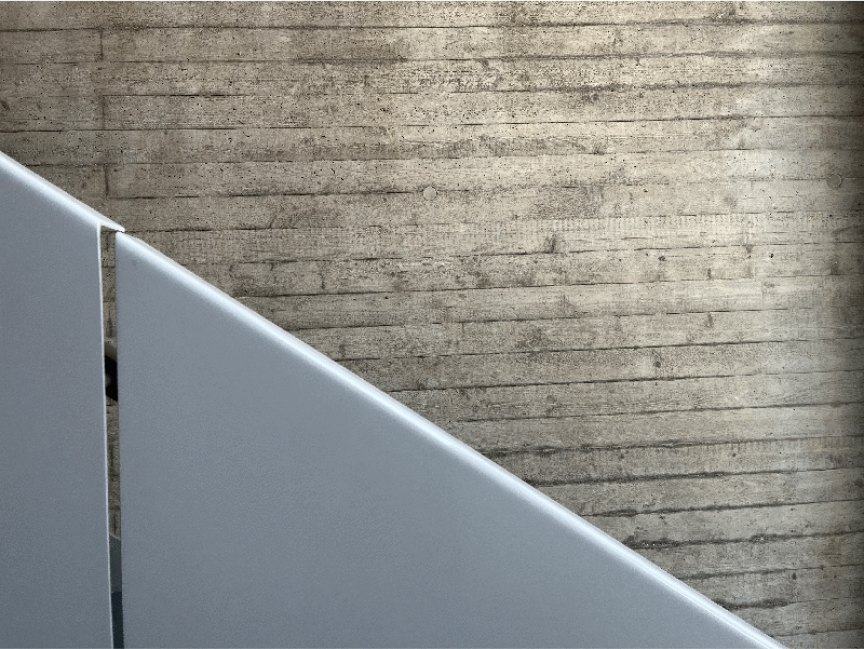 Seitenansicht des Geländers der Metalltreppe im Treppenhaus der Netzbewegung. Im Hintergrund eine Sichtbeton-Wand.