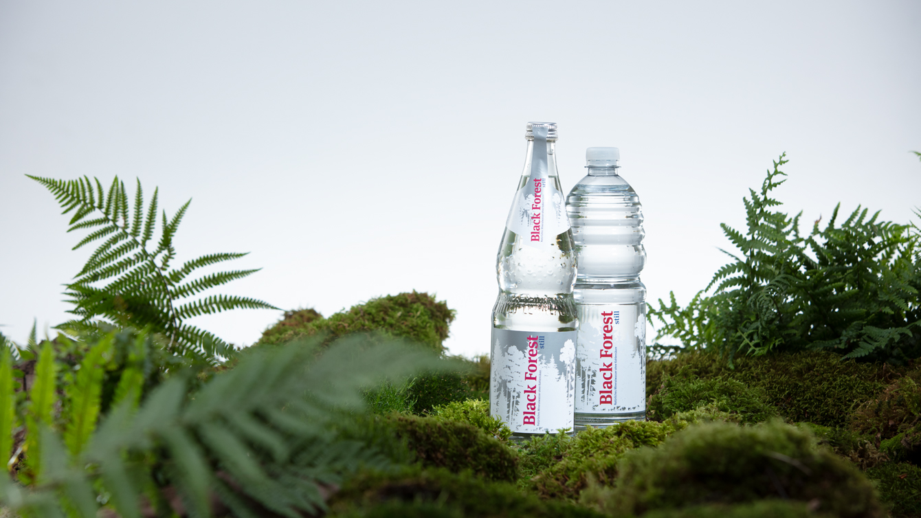 Zwei Mineralwasserflaschen von Blackforest auf grünem bemoosten Waldboden