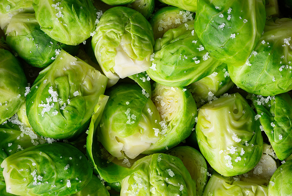 Grüner Rosenkohl mit grobem Salz in Nahaufnahme