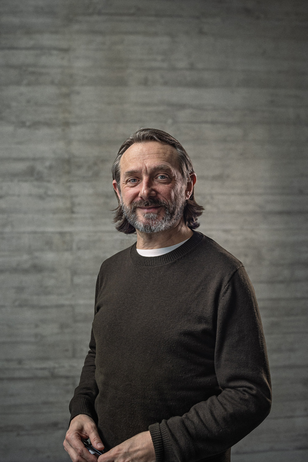 Portrait des Creative-Director Konzept vor einer Sichtbetonwand.